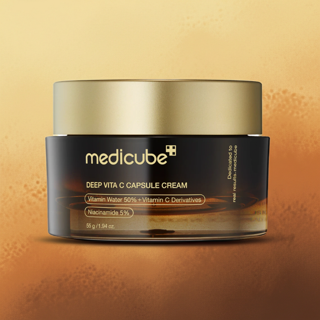 Crema viso in vasetto basso nero con tappo cilindrico dorato, etichetta Medicube e formula alla vitamina C.