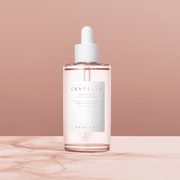 Ampolla viso Madagascar Centella in flacone trasparente con liquido rosato, contagocce bianco ed etichetta SKIN1004