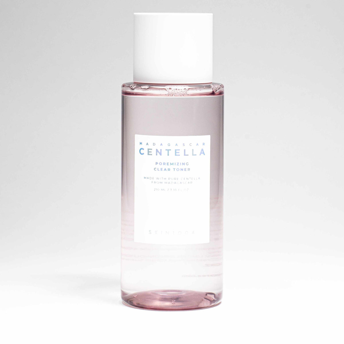 Tonico Madagascar centella poremizing in flacone trasparente con liquido rosato, tappo bianco ed etichetta chiara