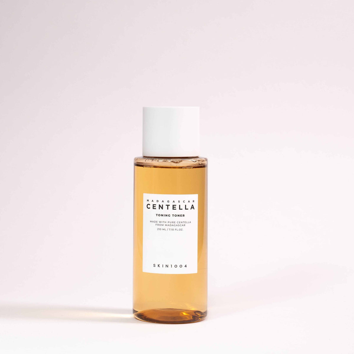 Tonico viso Madagascar centella in flacone trasparente con liquido ambrato, tappo bianco ed etichetta bianca SKIN1004.